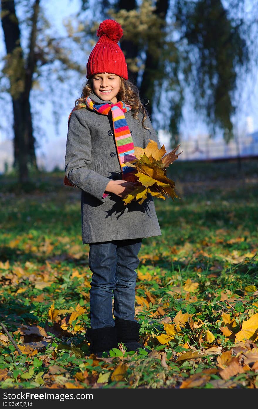 Little Miss. Pretty cute girl walks in autumn park