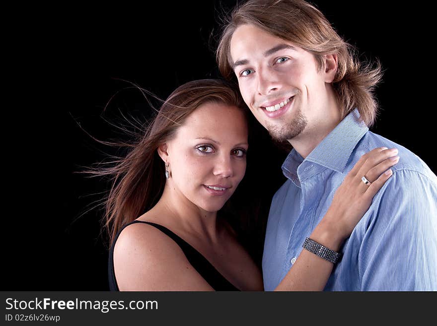 Young cute couple with long hair over black background. Young cute couple with long hair over black background.