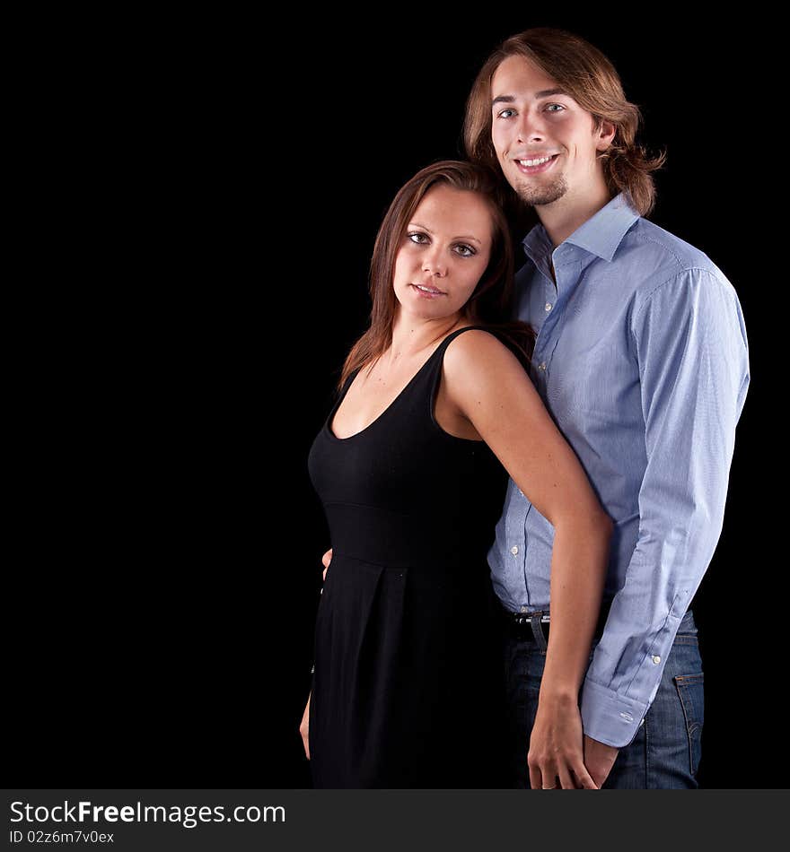 Young cute couple with long hair over black background. Young cute couple with long hair over black background.