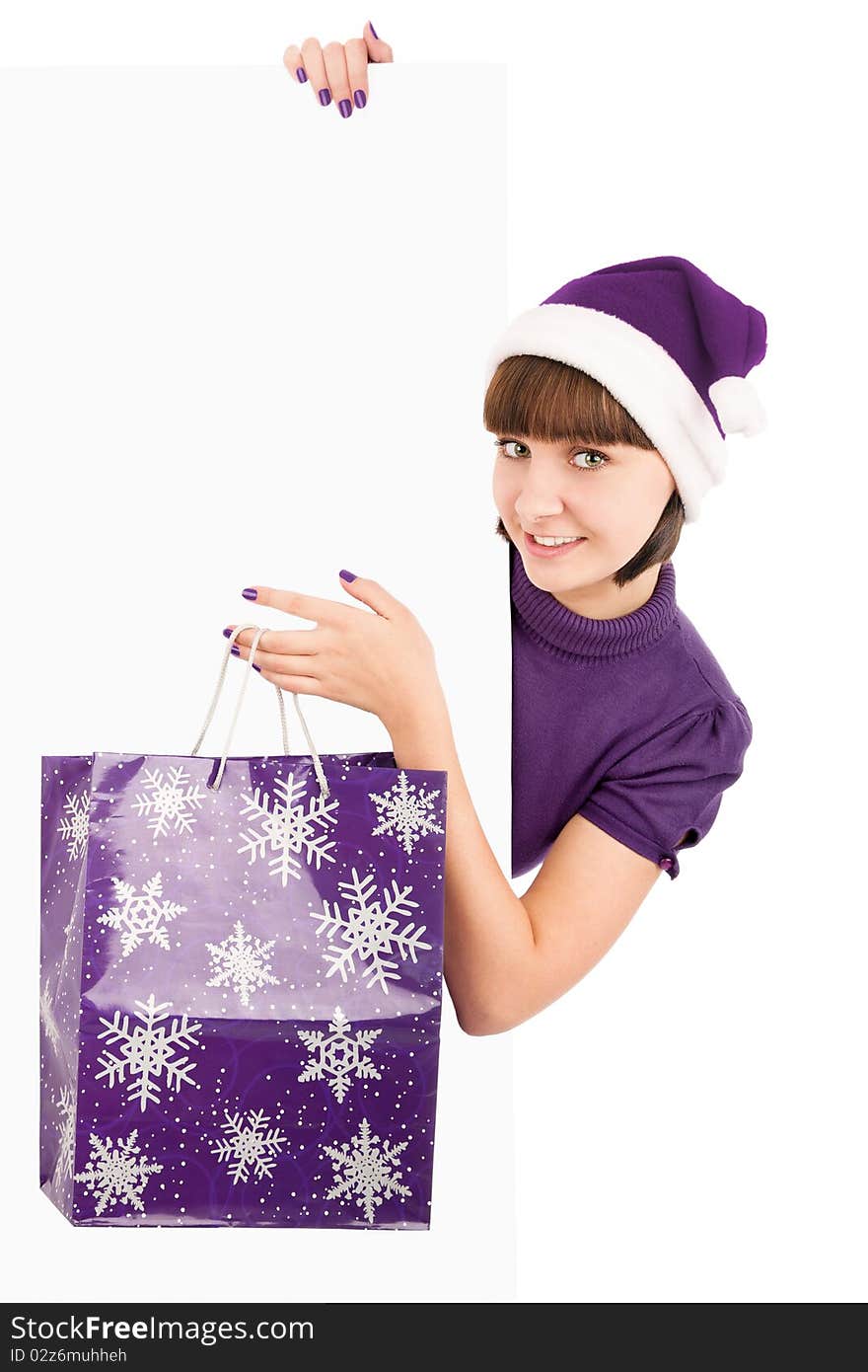 Smiling woman with shopping bag in Santa hat holding blank billboard, isolated on white. Smiling woman with shopping bag in Santa hat holding blank billboard, isolated on white