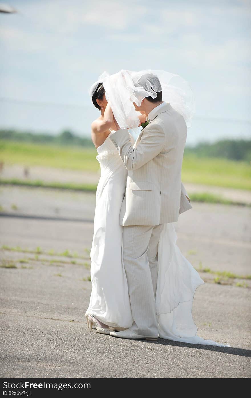 Groom and the bride in a white dress dance on an airfield. Groom and the bride in a white dress dance on an airfield