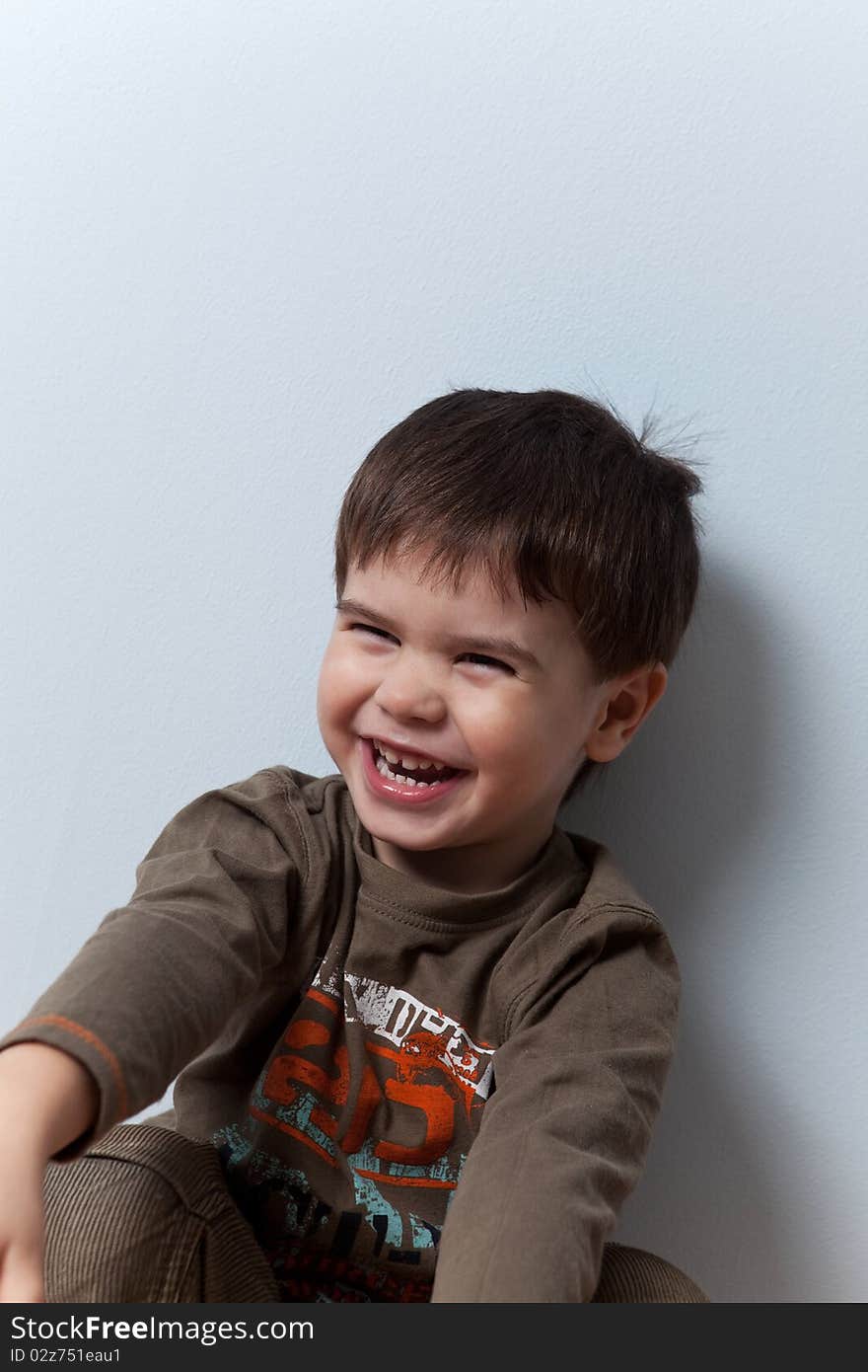 Smiling three year old boy studio portrait on background