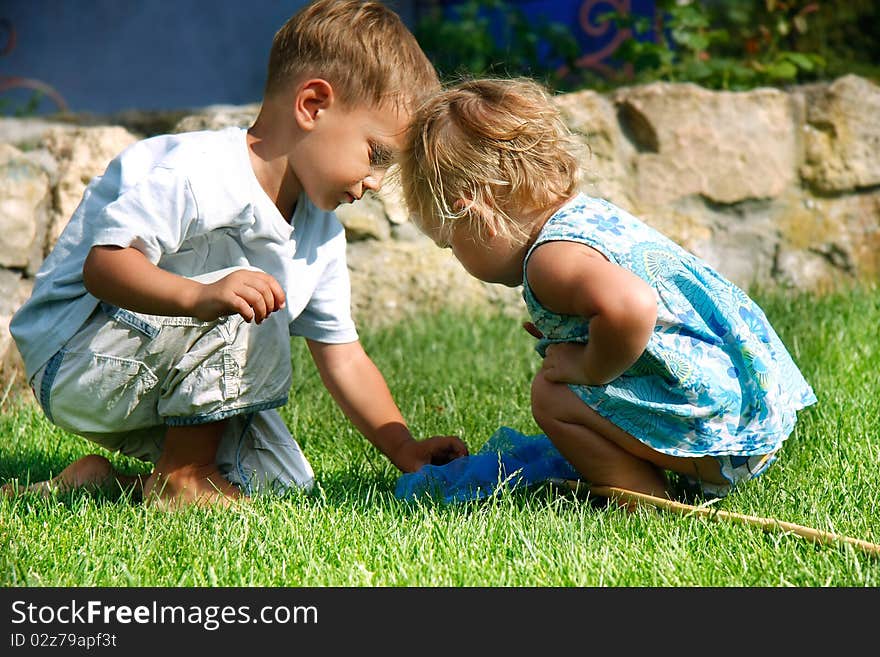 Brother and sister playing in green grass