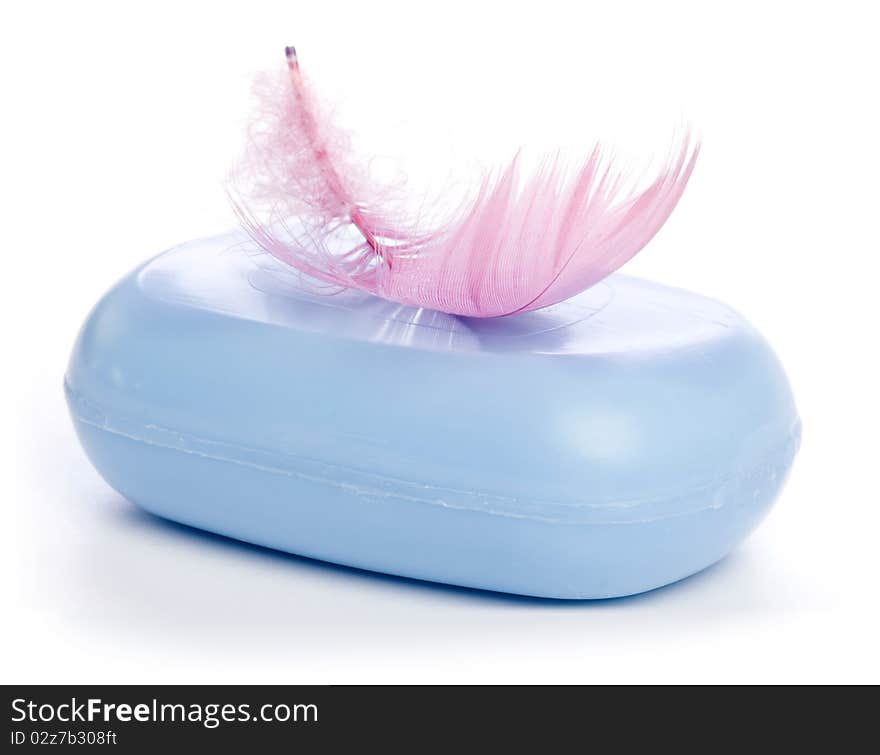 Blue new Soap Bar with pink Feather in soft-focus view. Isolated on white background.