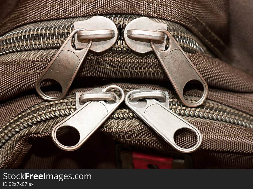 Closeup view of closed zippers on a bag.