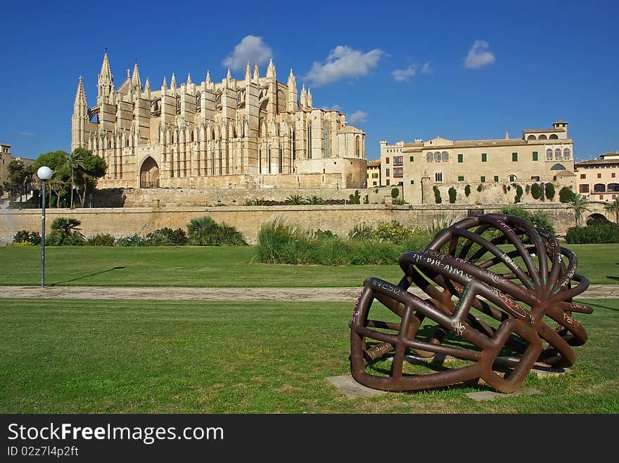 Modern abstract metallic sculpture in the foreground of the Palma de Mallorca gothic cathedral. Modern abstract metallic sculpture in the foreground of the Palma de Mallorca gothic cathedral