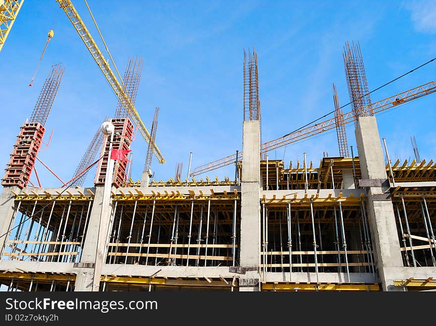 Two tower cranes over an under construction building