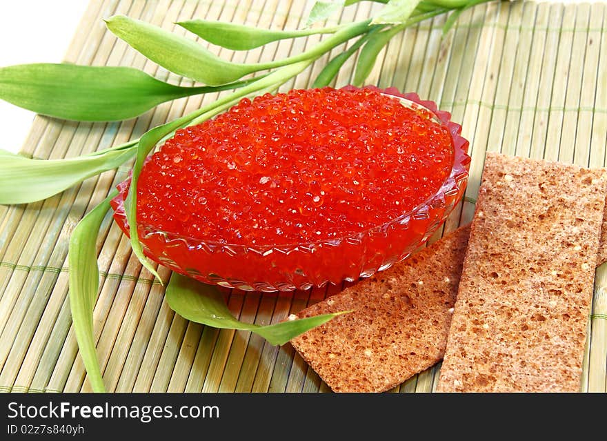 Glass flat dish with red caviar