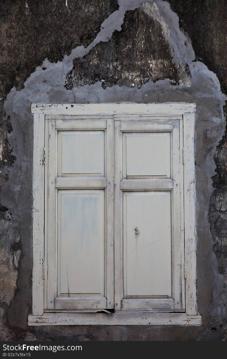 Old white window on the dirty concrete wall. Old white window on the dirty concrete wall