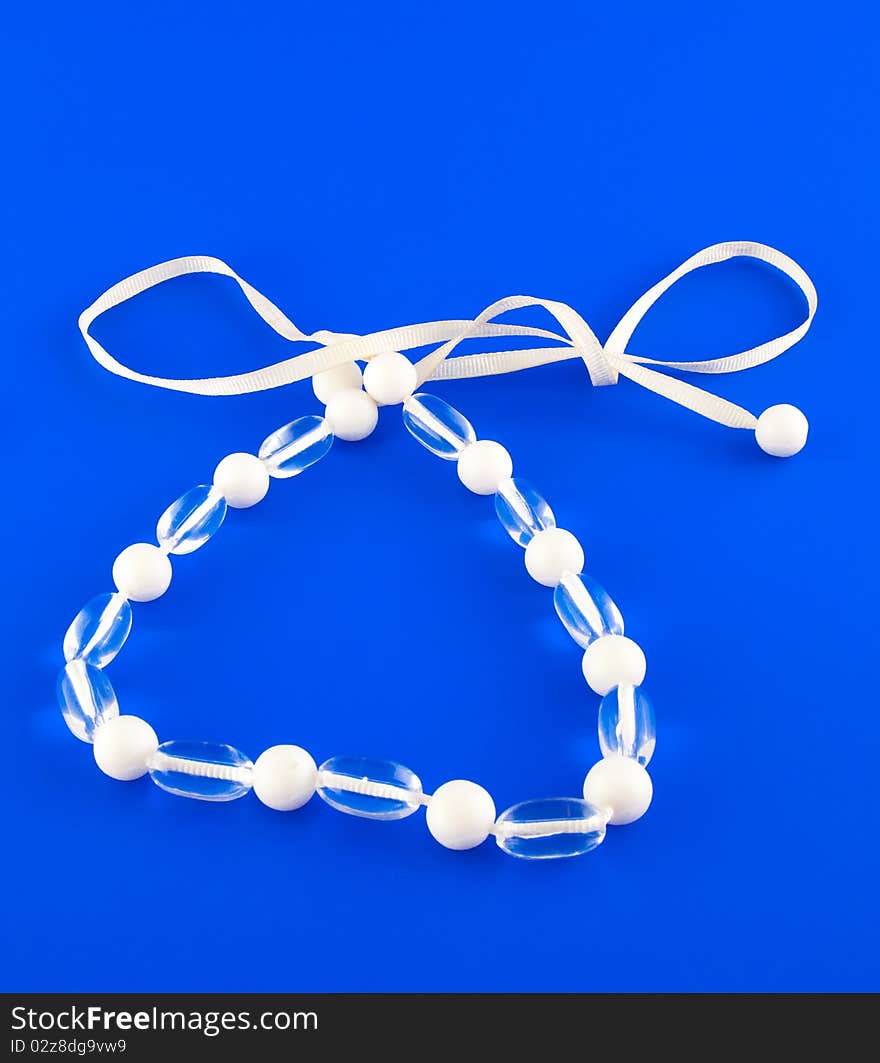 White isolated beads over blue background. Image. White isolated beads over blue background. Image.