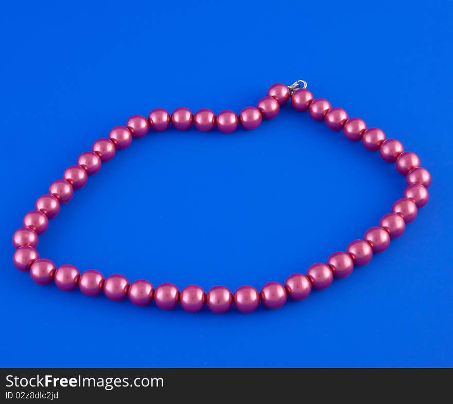 Red isolated beads over blue background. Image. Red isolated beads over blue background. Image.