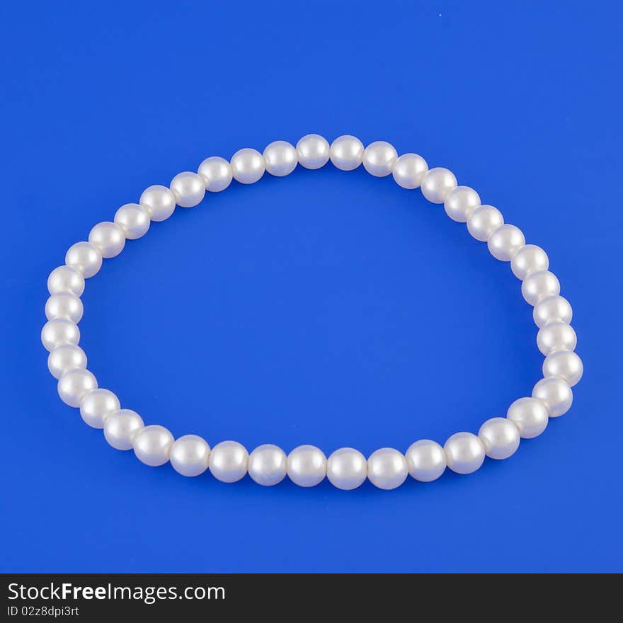 White isolated beads over blue background. Image. White isolated beads over blue background. Image.