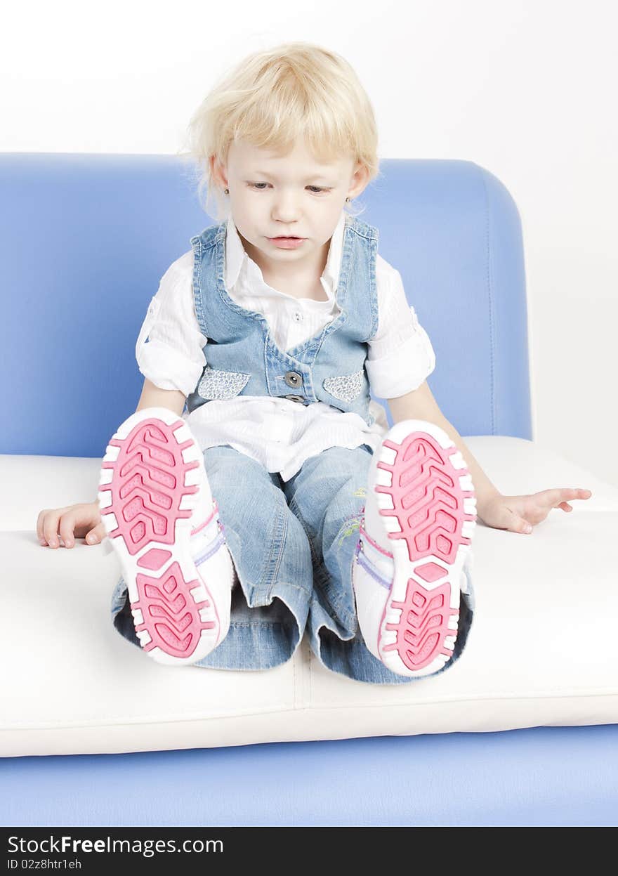 Little girl sitting on sofa. Little girl sitting on sofa