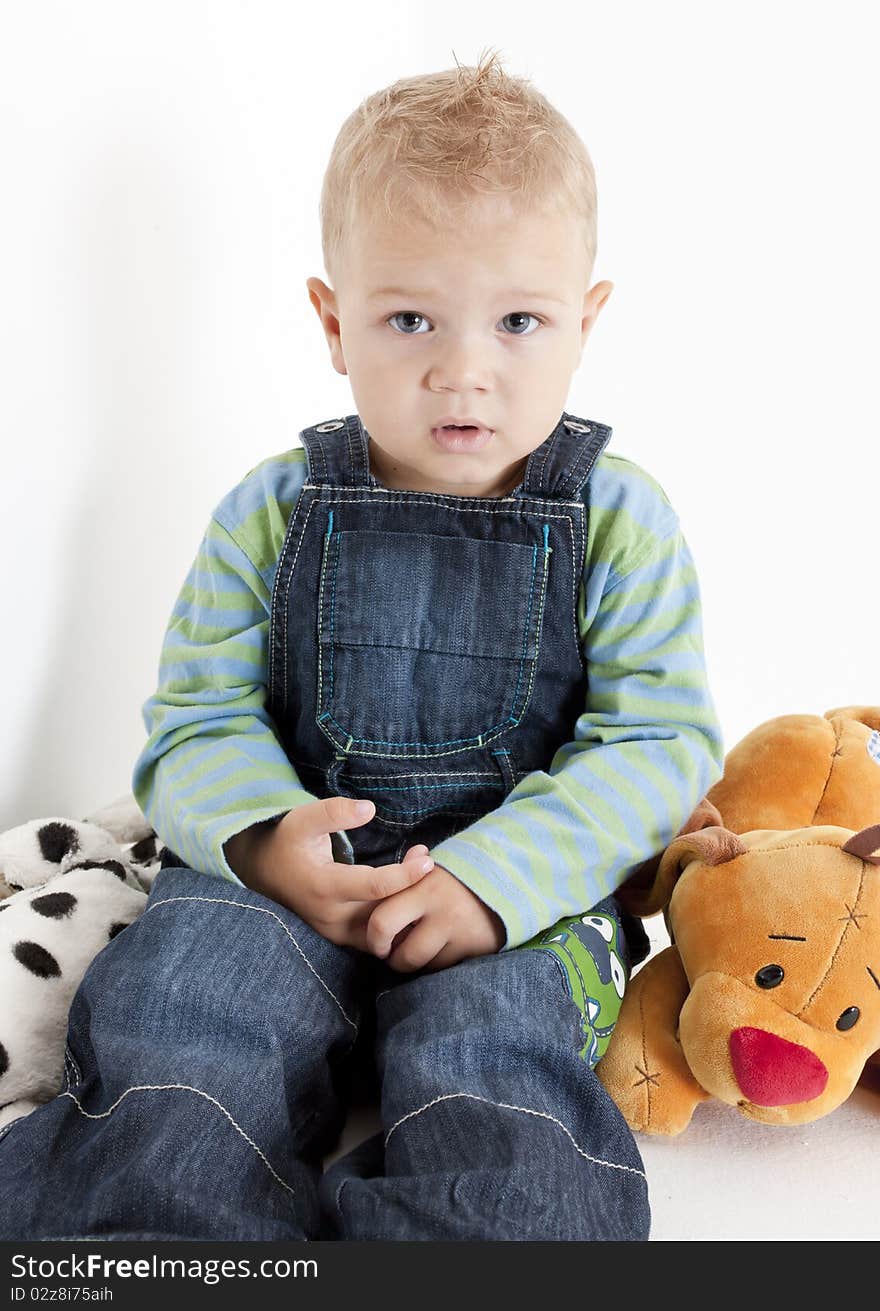 Sitting toddler boy with toys