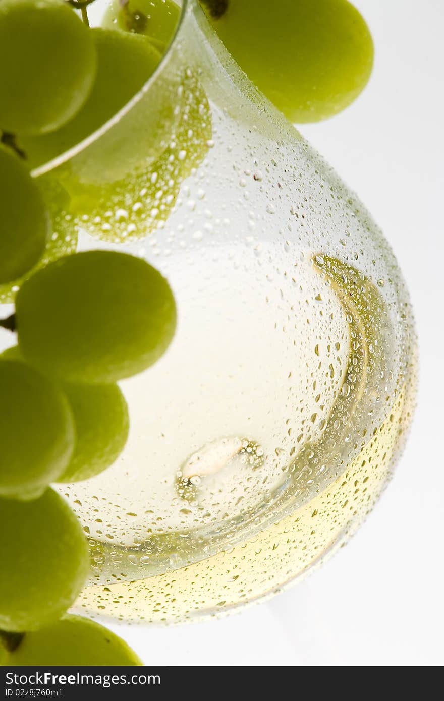 Wineglass with white wine and grape