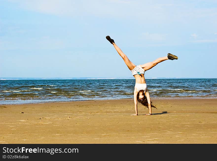 Young woman making exercise on the beach. Young woman making exercise on the beach.