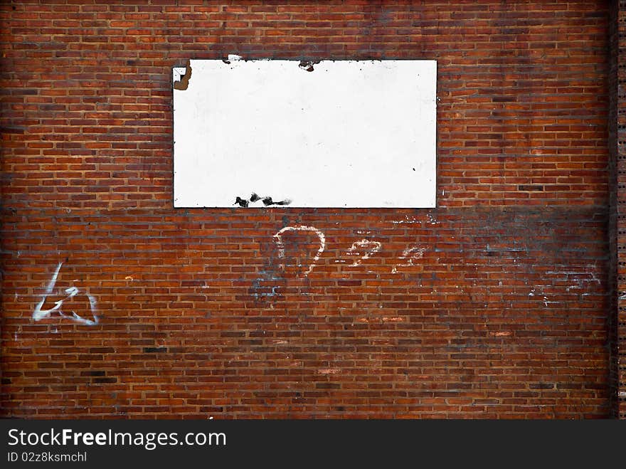 White blank billboard on a stone wall.