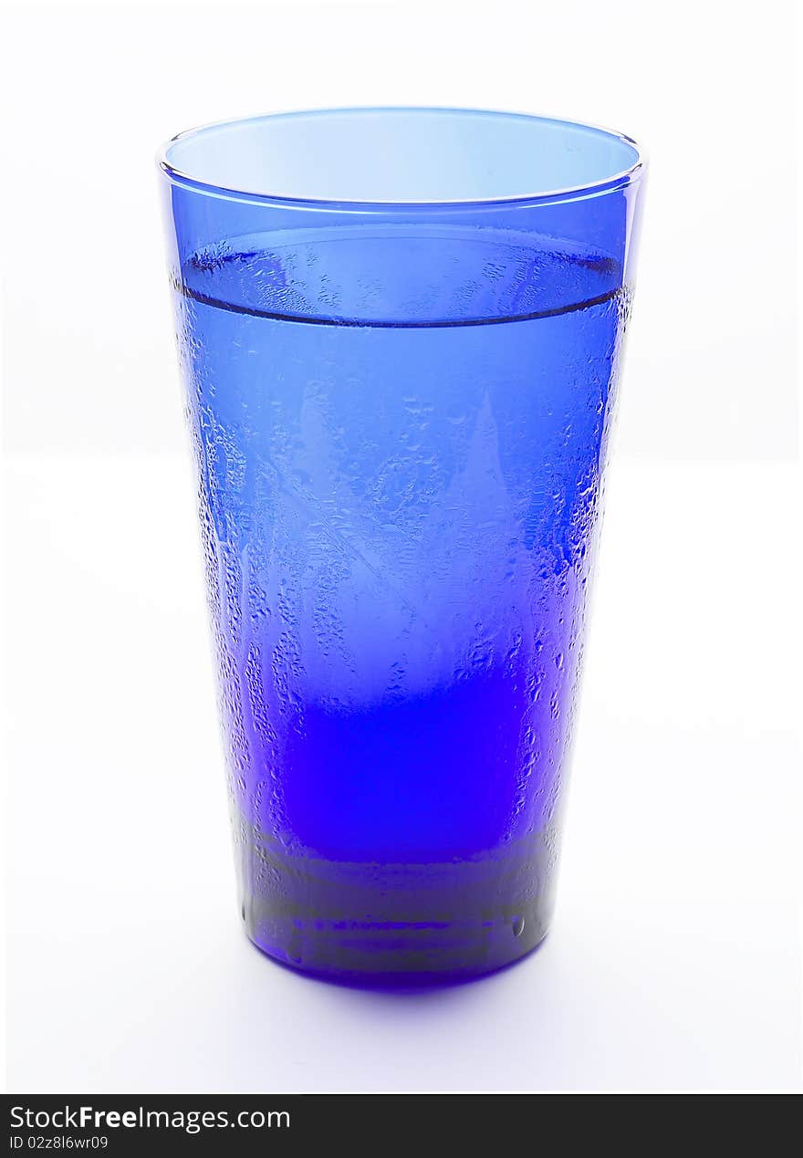 A blue glass filled with cold water. A blue glass filled with cold water