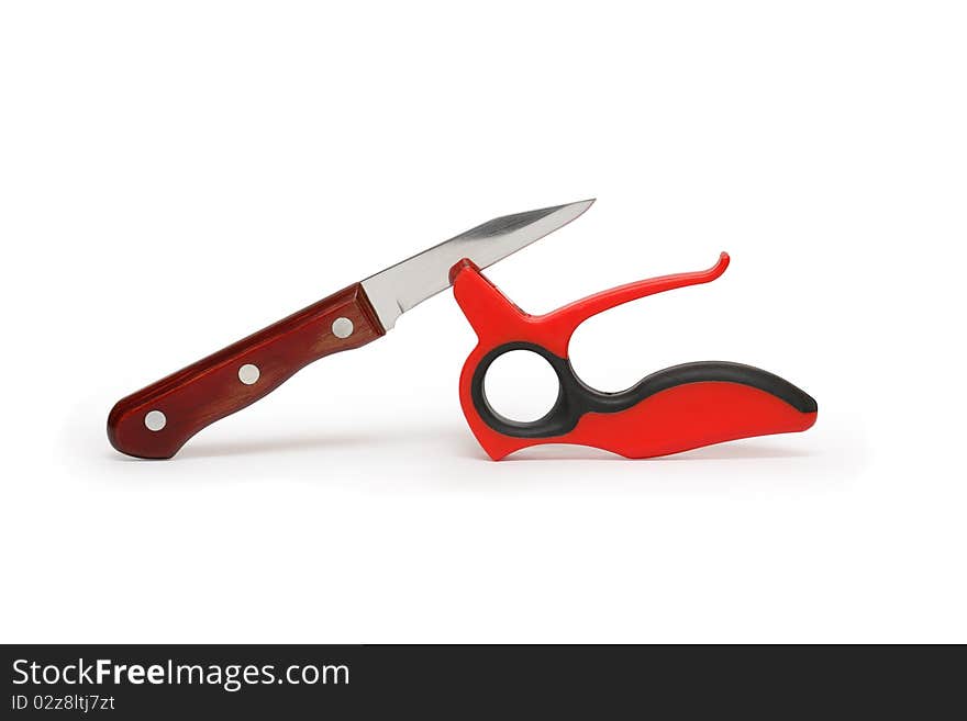 Red plastic knife sharpener and kitchen knife isolated on white background with clipping path. Red plastic knife sharpener and kitchen knife isolated on white background with clipping path