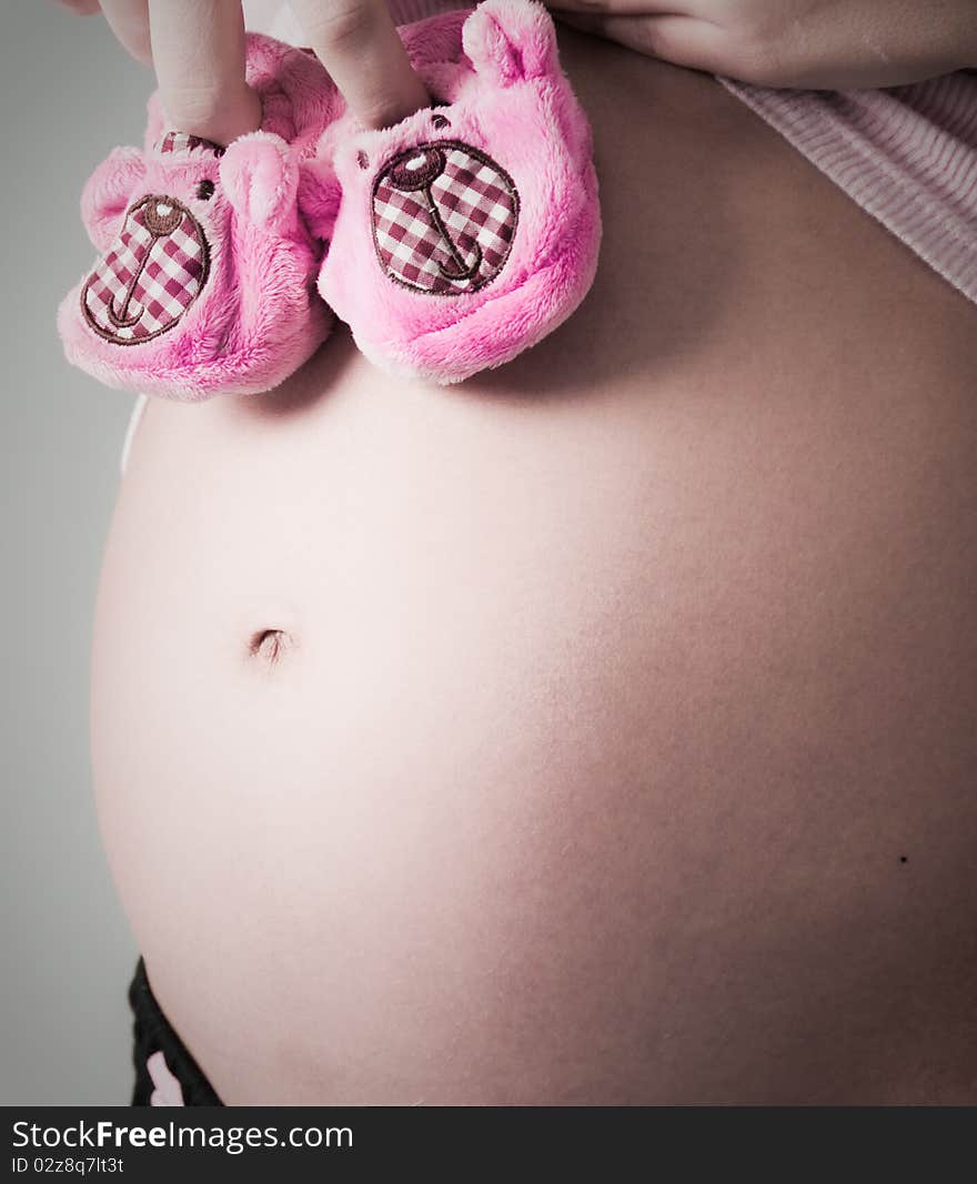 A pregnant beautiful woman. Grey Background. A pregnant beautiful woman. Grey Background