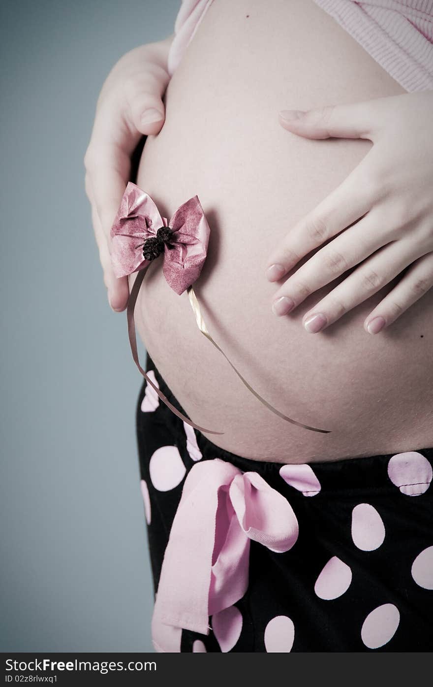 A pregnant beautiful woman. Grey Background. A pregnant beautiful woman. Grey Background