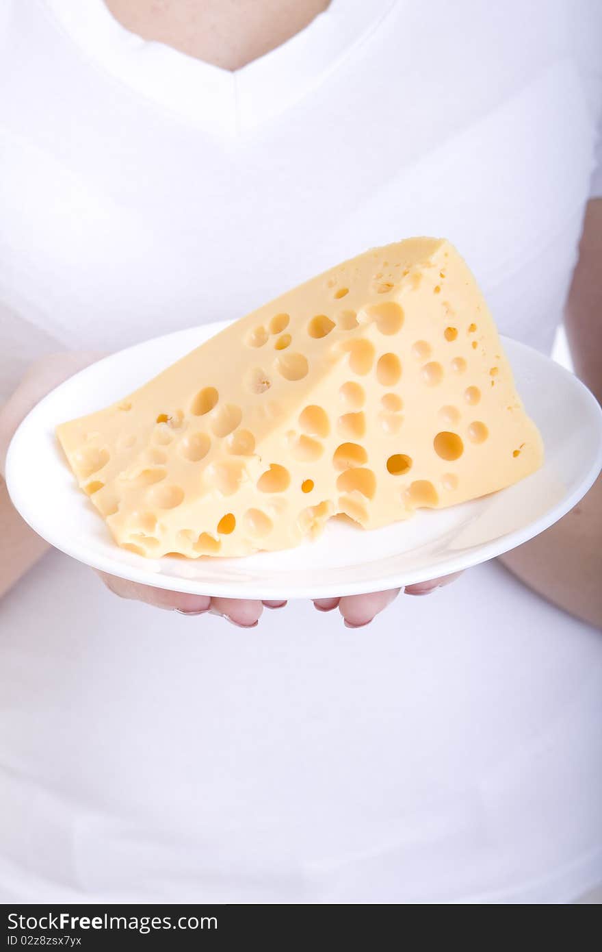 Slice of cheese on a plate, in the hands of a girl. Slice of cheese on a plate, in the hands of a girl