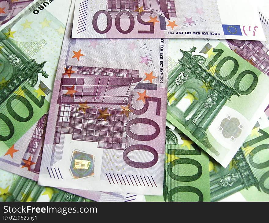 Background of scattered 100 and 500 euro banknotes