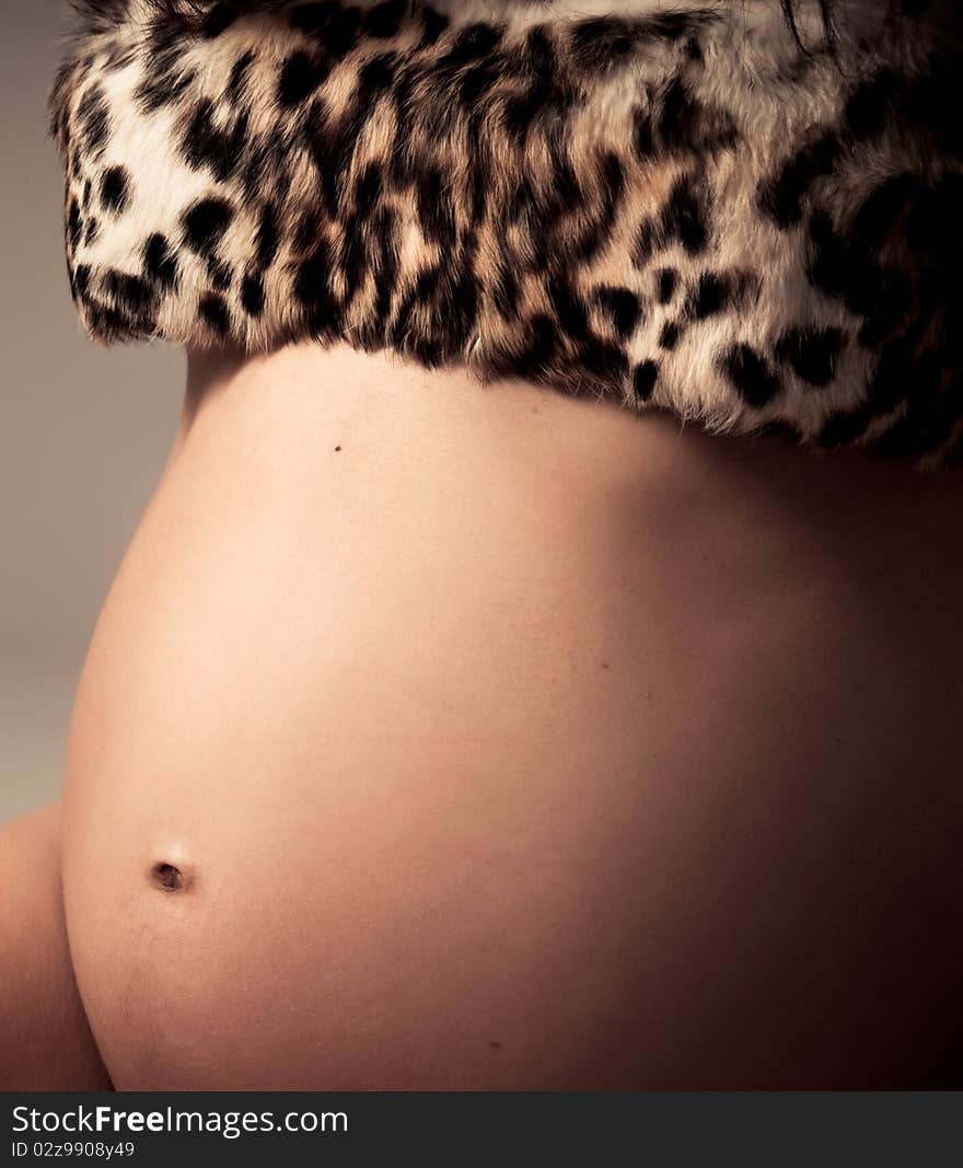 Young pregnant woman posing with a belly