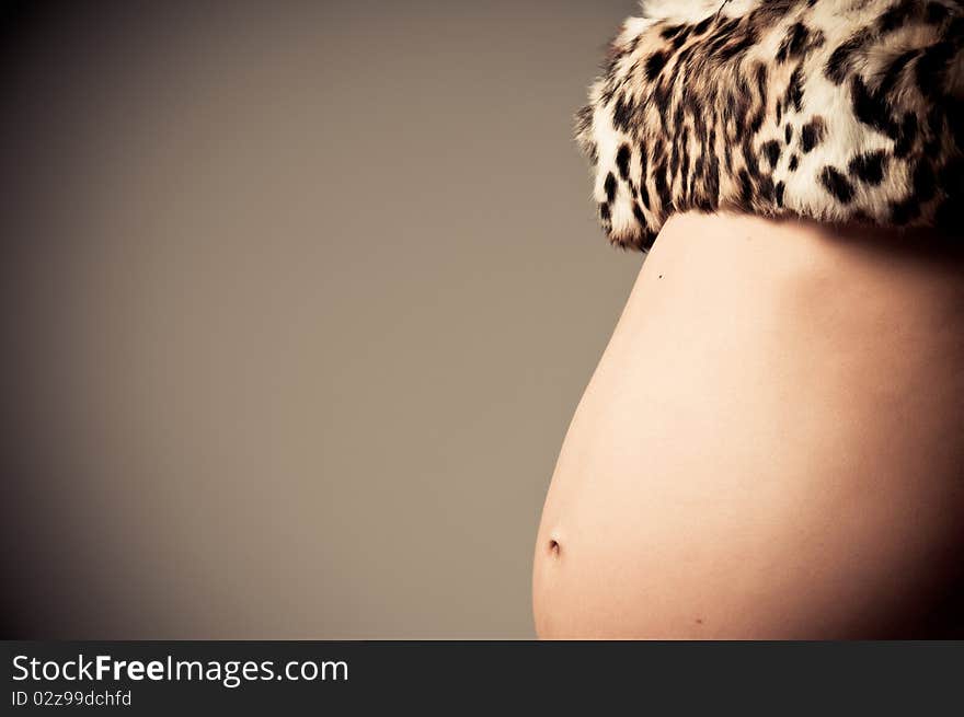 Young pregnant woman posing with a belly