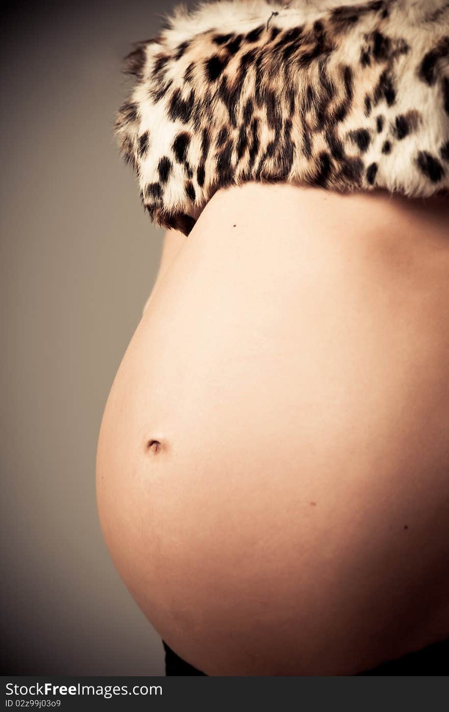 Young pregnant woman posing with a belly