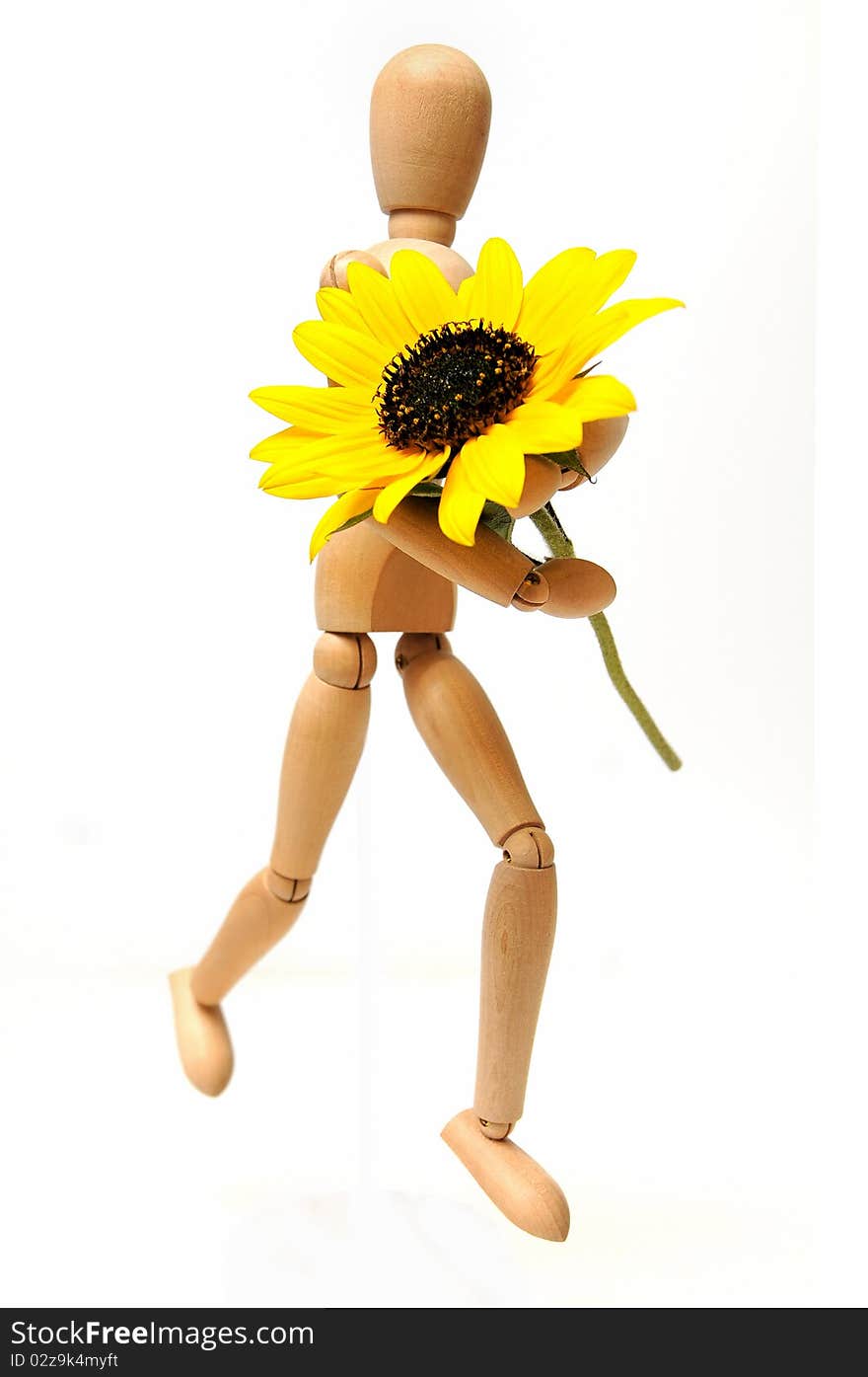 Wood figure with sunflower in arms over white background