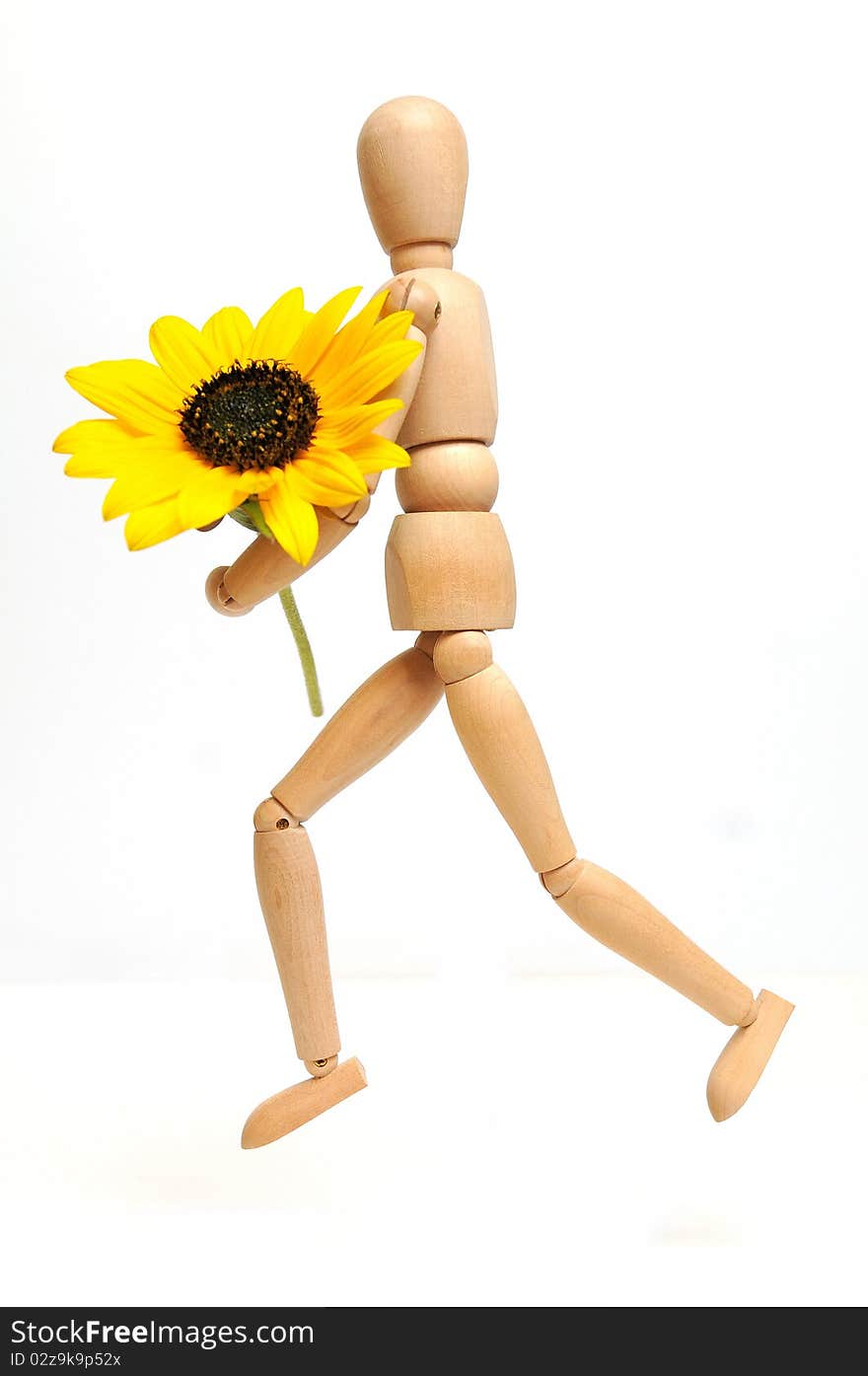 Wood figure with sunflower in arms over white background