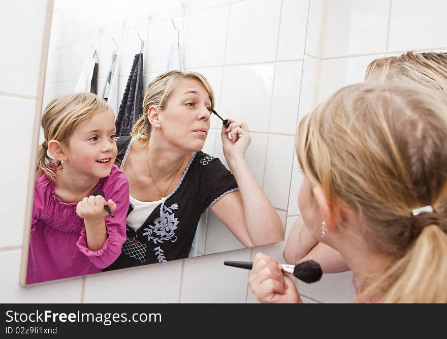 Mother and daughter put on make-up