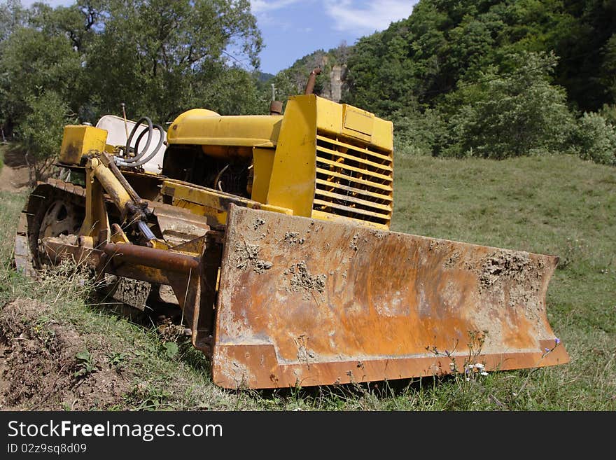 Old bulldozer waiting for work. It is located near an old village, deep into the Carpathians mountains