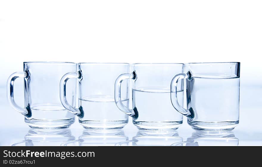 Four blue cups filled with water unevenly. Four blue cups filled with water unevenly