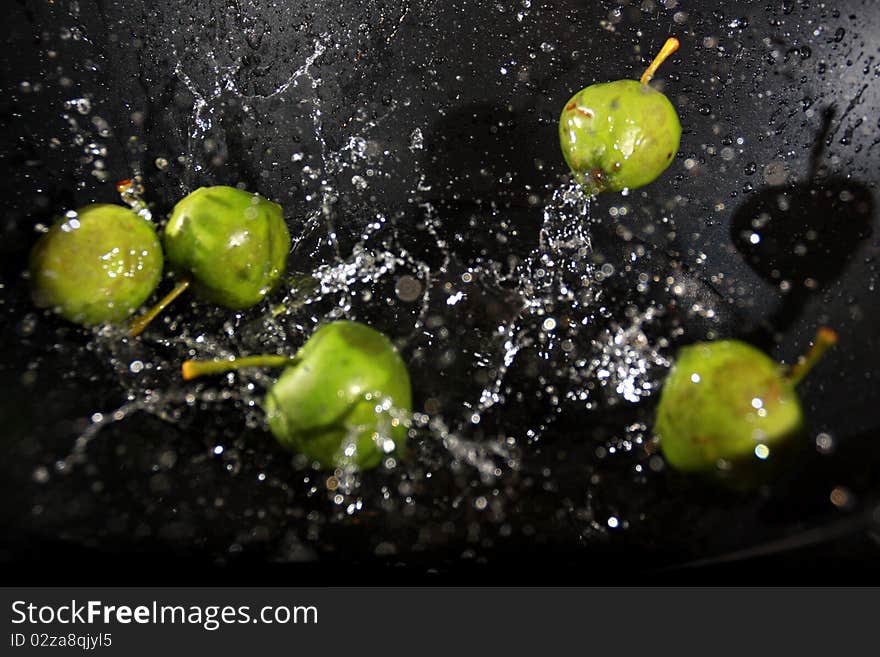 Small apples being dropped in water. Small apples being dropped in water