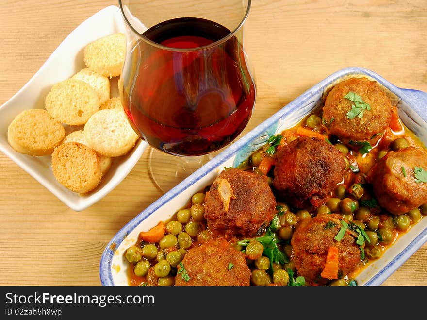 Croutons with meatballs in tomato sauce with peas