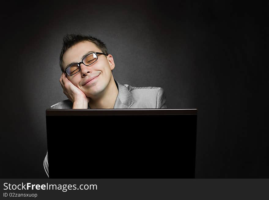 Dreaming businessman with laptop on black background