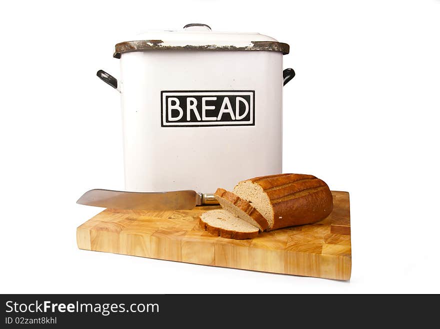 A white vintage bread tin with bread and a knife on a wooden board isolated on a white background