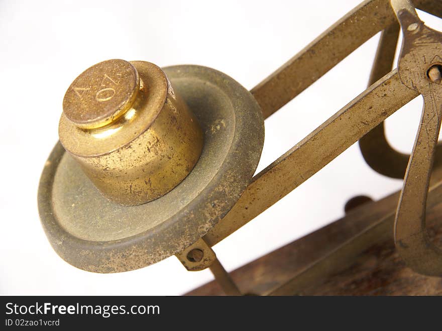 Four ounce weight isolated on a vinatage scale isolated on a white background. Four ounce weight isolated on a vinatage scale isolated on a white background