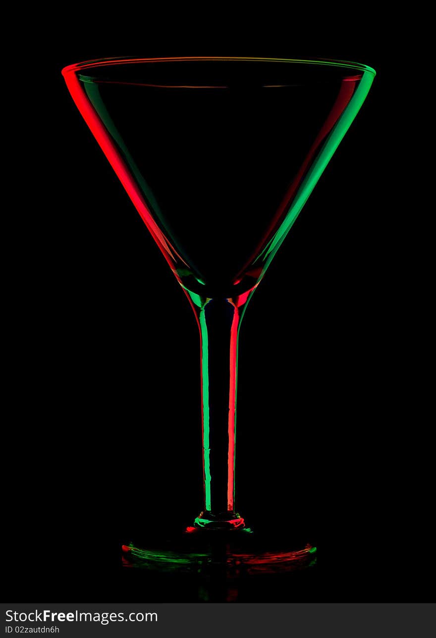 Transparent colored empty martini glass, isolated on black. Transparent colored empty martini glass, isolated on black