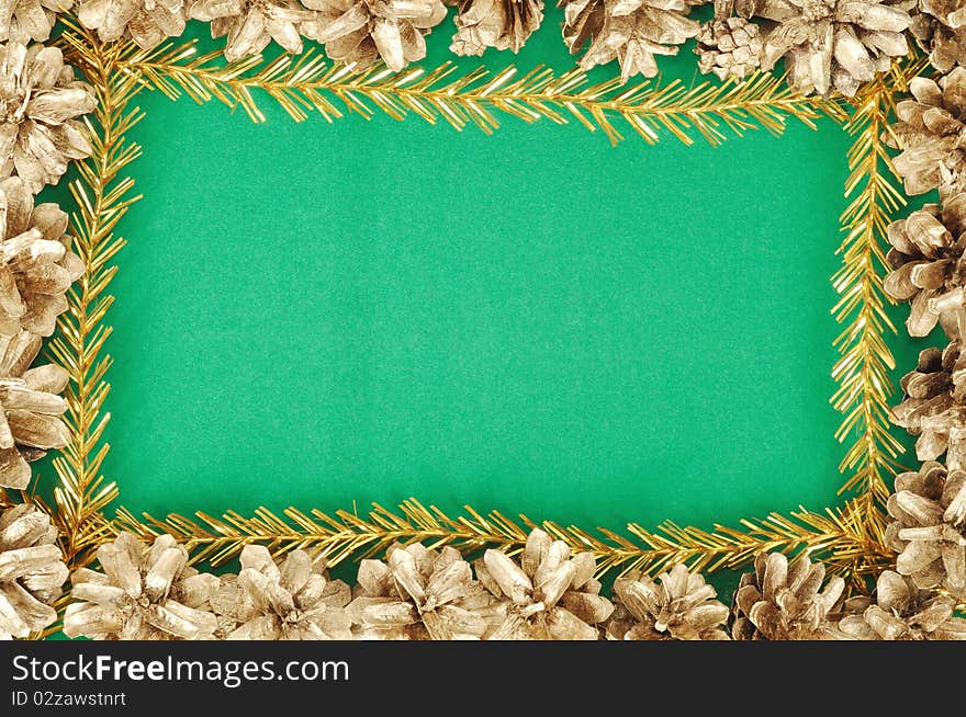 Green christmas background with gold cones frame