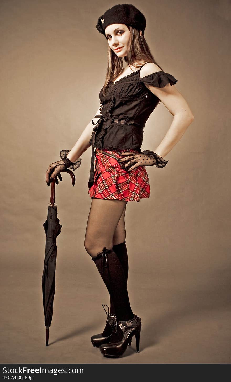 Gothic girl with umbrella, studio shot over white background