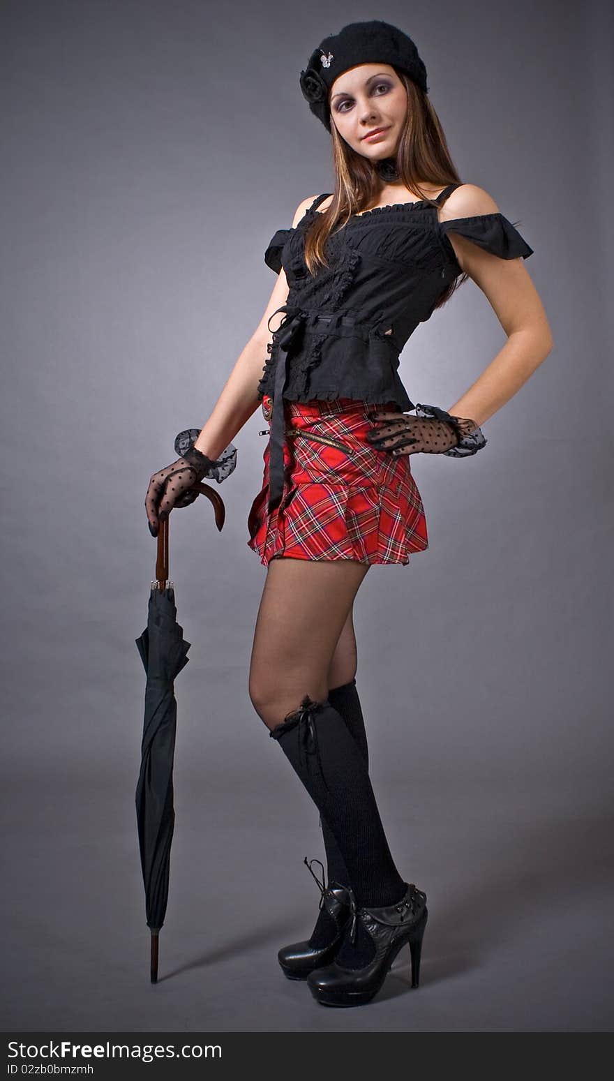 Funny gothic girl with umbrella, studio shot over white background