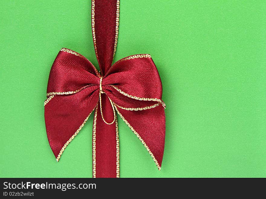 Gift in green wrapping with a red bow in close up. Gift in green wrapping with a red bow in close up