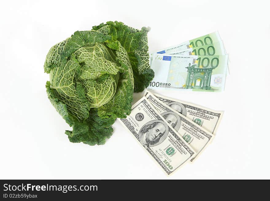 A head of savoy cabbage with three one hundred dollar and three one hundred euro banknotes on white background. A head of savoy cabbage with three one hundred dollar and three one hundred euro banknotes on white background