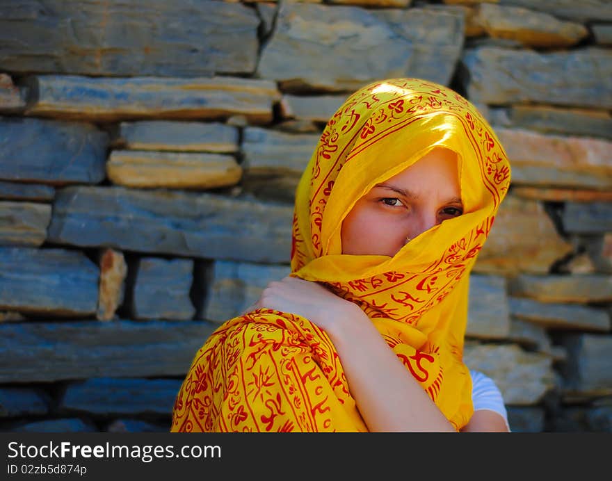 Young woman with yellow veil covering her face