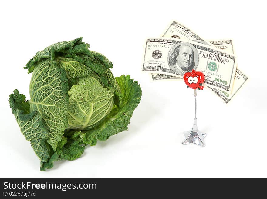 A head of savoy cabbage with three one thundred dollar banknotes on white background. A head of savoy cabbage with three one thundred dollar banknotes on white background