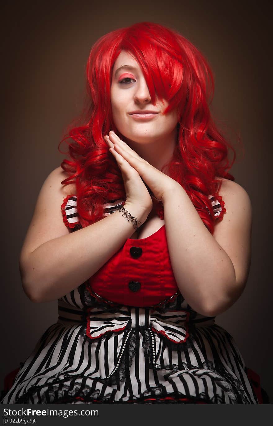 Attractive Red Haired Woman Wearing Bunny Ear Hat on a Grey Background.