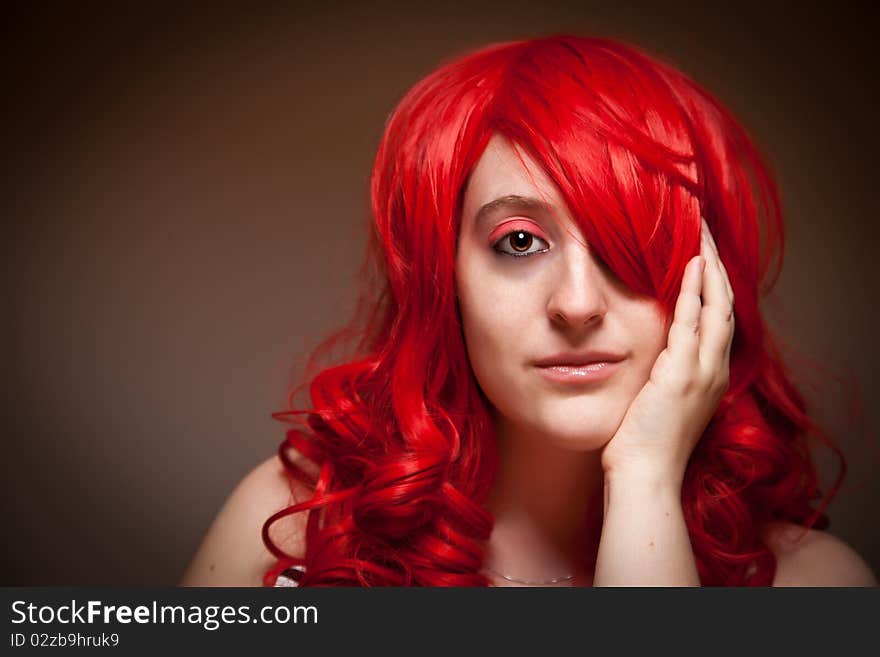 Attractive Red Haired Woman Wearing Bunny Ear Hat on a Grey Background.